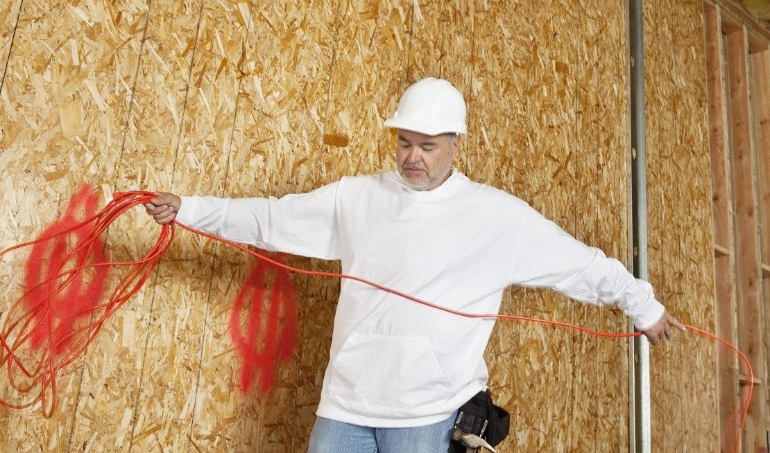 Mature male construction worker with an electrical wire